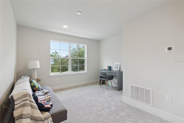 carpeted office space featuring visible vents and baseboards