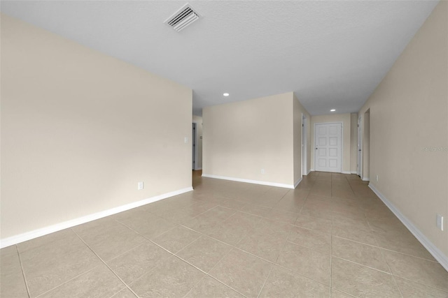 tiled empty room with baseboards and visible vents