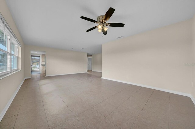 spare room featuring light tile patterned floors, visible vents, baseboards, and ceiling fan