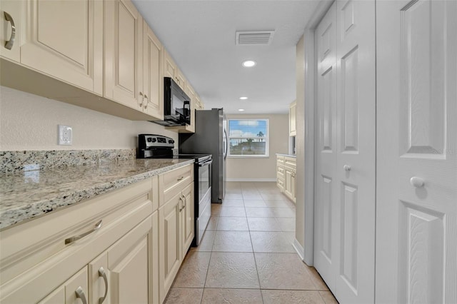 kitchen with cream cabinetry, visible vents, and stainless steel appliances