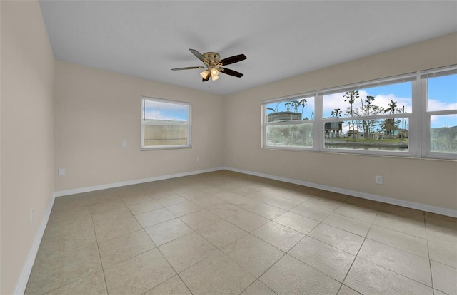 unfurnished room with ceiling fan, baseboards, and light tile patterned flooring