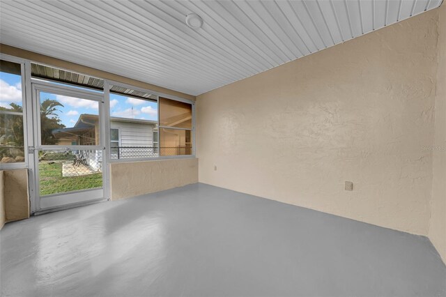 empty room with finished concrete floors and a textured wall