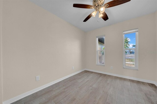 empty room featuring baseboards, light wood-style floors, and ceiling fan