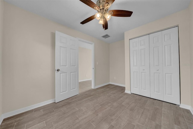 unfurnished bedroom featuring a ceiling fan, baseboards, visible vents, light wood-style floors, and a closet