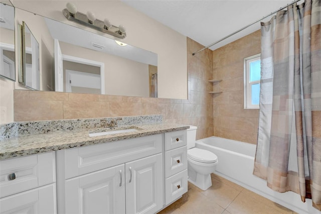 bathroom with vanity, tile patterned flooring, shower / bath combo with shower curtain, tile walls, and toilet