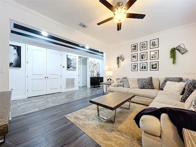 living room with ceiling fan, ornamental molding, wood finished floors, and visible vents