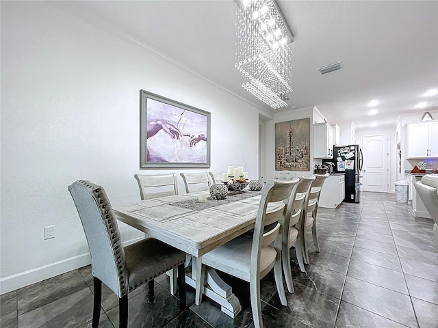 dining room featuring baseboards, visible vents, and an inviting chandelier