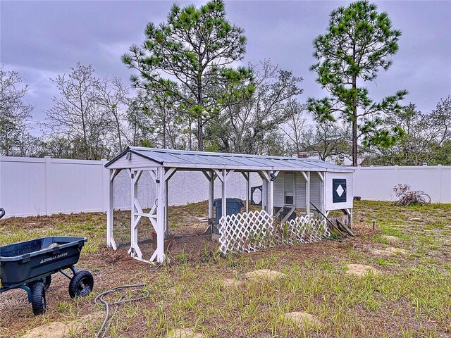 view of yard featuring an outdoor structure, a fenced backyard, and exterior structure