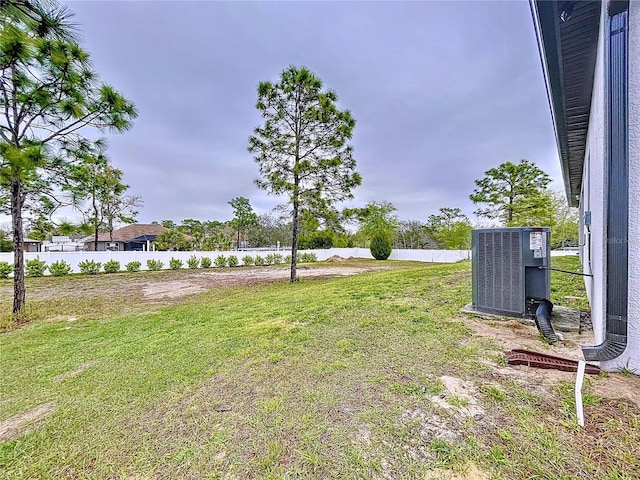 view of yard featuring central AC unit and fence