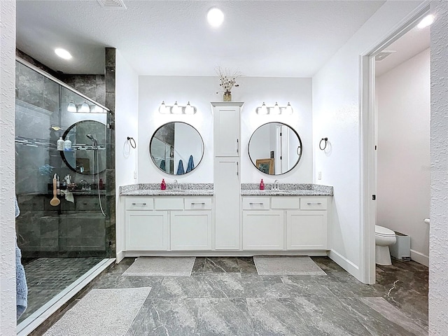 full bath featuring a stall shower, baseboards, vanity, and toilet