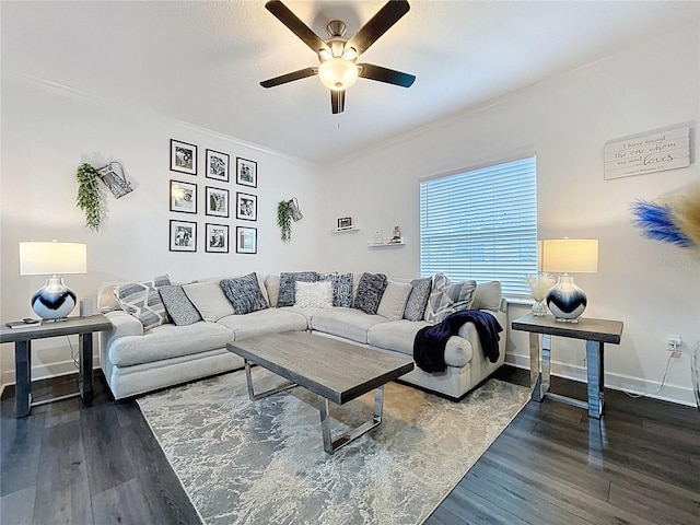 living area featuring dark wood-type flooring, crown molding, baseboards, and a ceiling fan