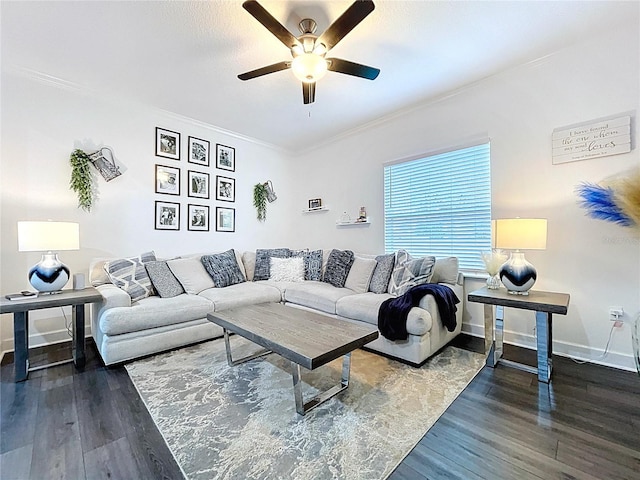 living area with crown molding, dark wood finished floors, baseboards, and ceiling fan