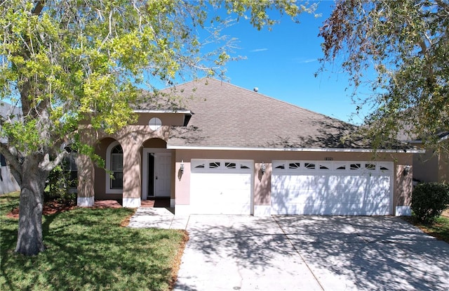 view of front facade with stucco siding, concrete driveway, a shingled roof, and a garage