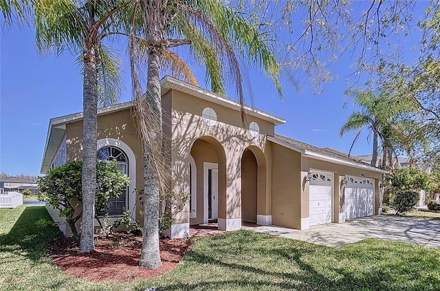 mediterranean / spanish-style house with decorative driveway, a front lawn, an attached garage, and stucco siding