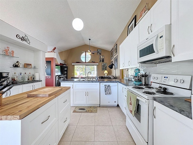 kitchen with white appliances, light tile patterned floors, wooden counters, a peninsula, and white cabinetry