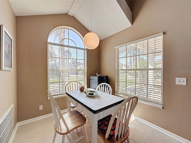 dining space with a wealth of natural light, light tile patterned floors, and baseboards