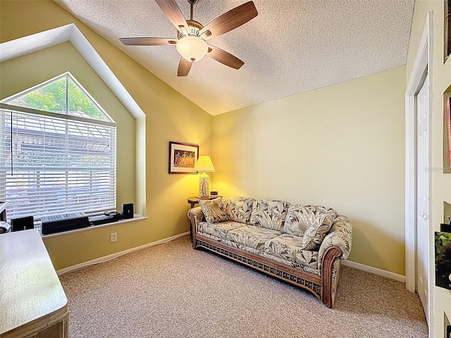 living area with baseboards, lofted ceiling, carpet flooring, a textured ceiling, and a ceiling fan