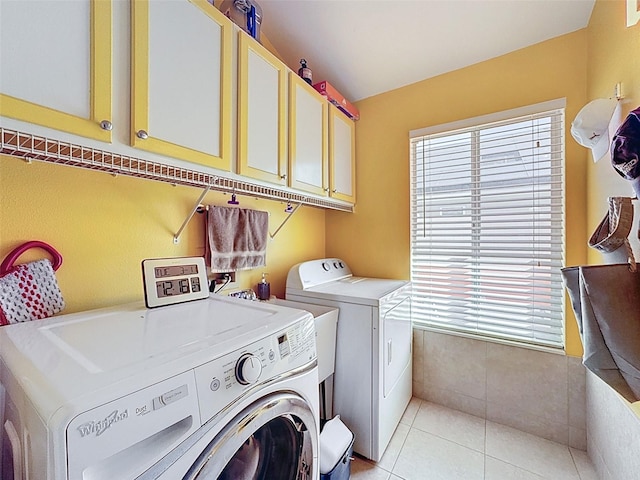 laundry area with cabinet space, light tile patterned floors, and separate washer and dryer