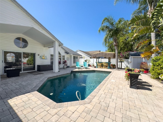 view of swimming pool with an outdoor structure, a patio area, a fenced in pool, and a fenced backyard