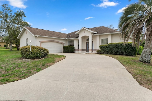 view of front facade featuring stucco siding, an attached garage, concrete driveway, and a front yard