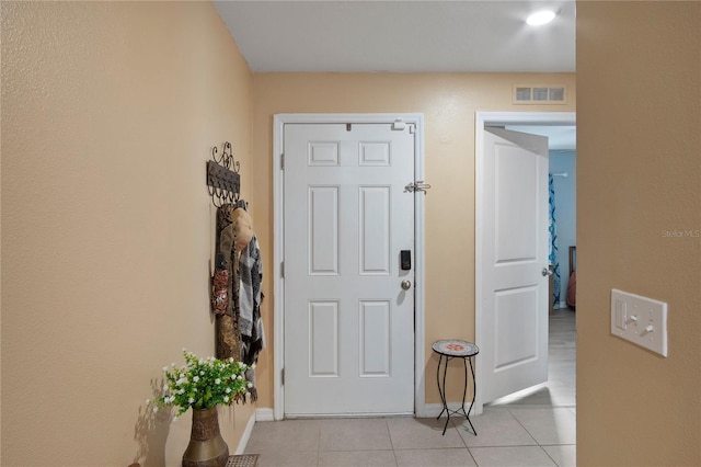 foyer featuring visible vents, baseboards, and light tile patterned floors