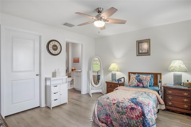 bedroom featuring a ceiling fan, visible vents, light wood-style flooring, and ensuite bath