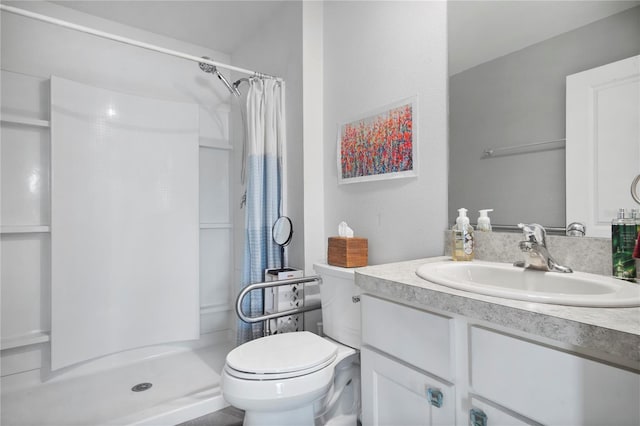 bathroom with a stall shower, vanity, and toilet