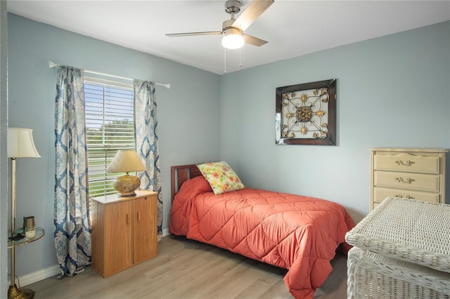 bedroom with baseboards, a ceiling fan, and light wood-style floors