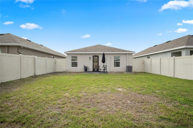 back of property with central AC, a yard, a fenced backyard, and stucco siding