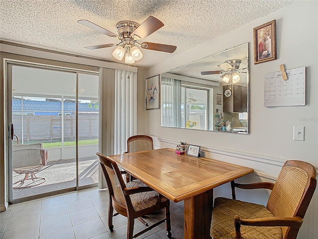 tiled dining space featuring a ceiling fan and a textured ceiling