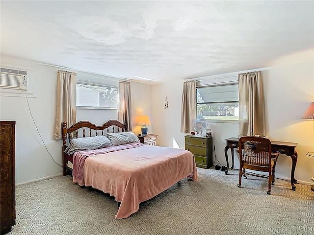 bedroom with carpet floors, an AC wall unit, and baseboards