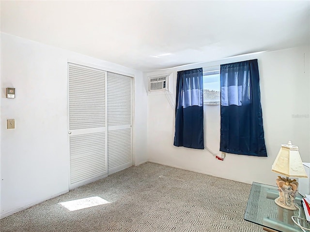 unfurnished bedroom featuring carpet floors, a wall mounted AC, and a closet