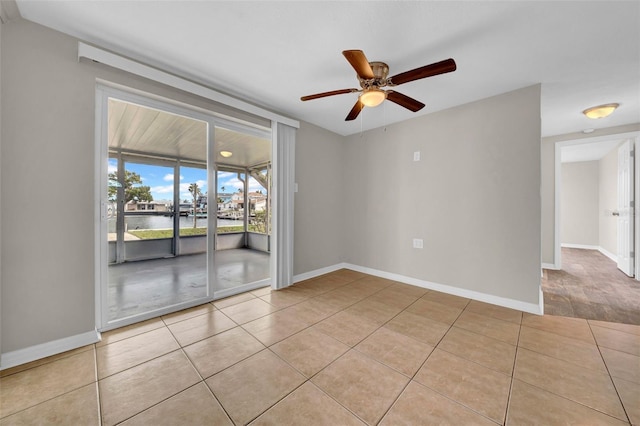 empty room with tile patterned floors, baseboards, and ceiling fan