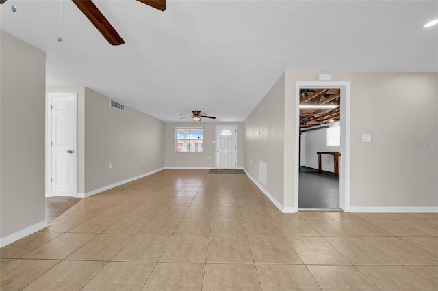 unfurnished living room with light tile patterned floors, visible vents, baseboards, and a ceiling fan