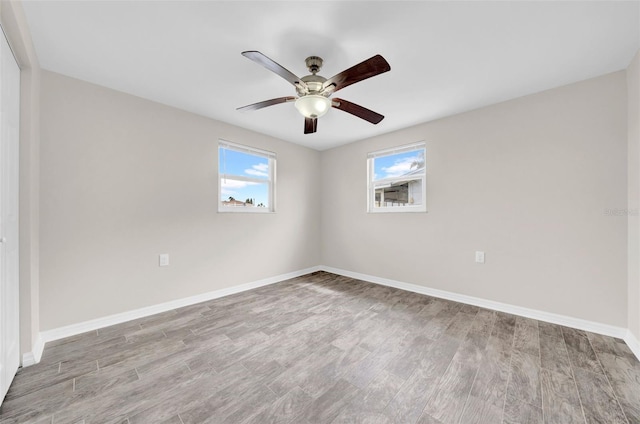 spare room with ceiling fan, baseboards, and wood finished floors