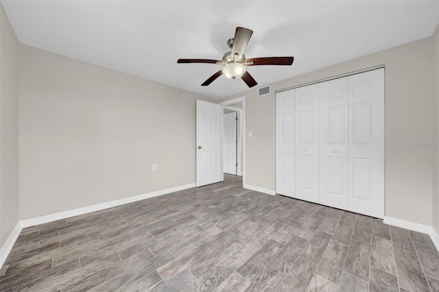 unfurnished bedroom featuring a ceiling fan, wood finished floors, visible vents, baseboards, and a closet