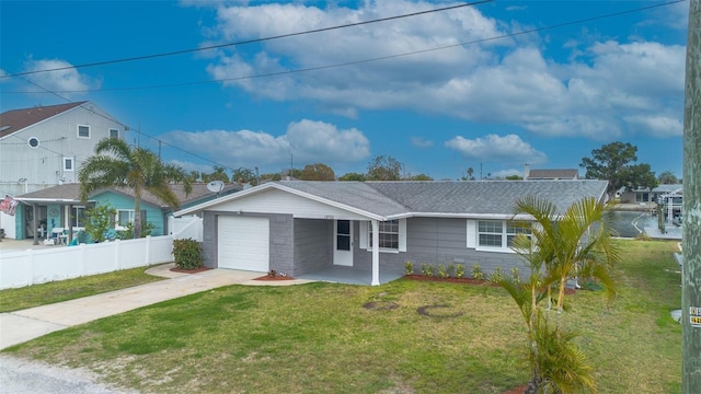 ranch-style home with fence, concrete driveway, roof with shingles, a front yard, and an attached garage