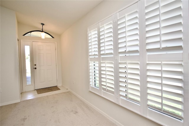 entrance foyer with baseboards, carpet, and tile patterned flooring