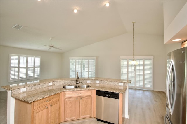 kitchen featuring visible vents, plenty of natural light, a sink, vaulted ceiling, and appliances with stainless steel finishes