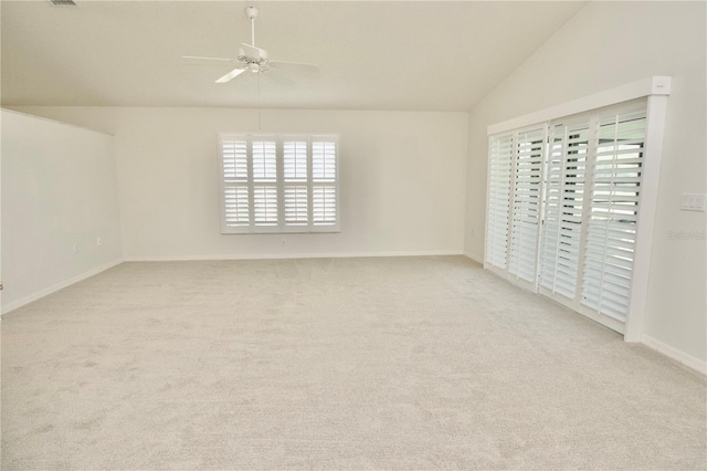 carpeted empty room with visible vents, baseboards, a ceiling fan, and vaulted ceiling