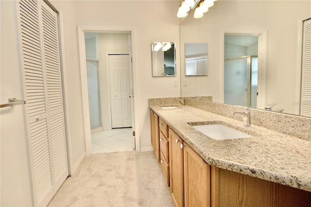 full bath featuring a closet, a shower stall, double vanity, and a sink