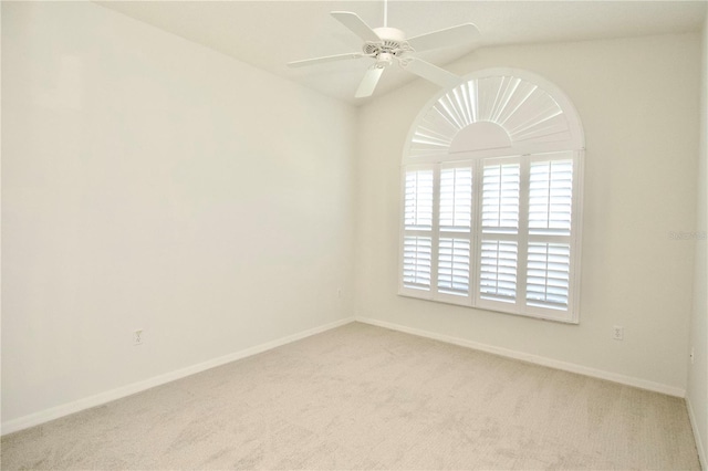 carpeted spare room with baseboards, ceiling fan, and vaulted ceiling