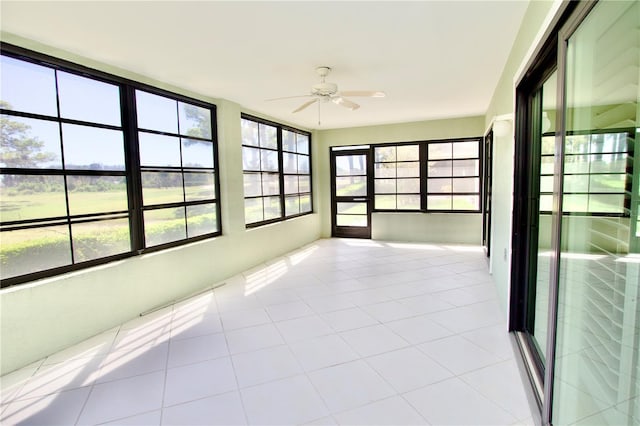 unfurnished sunroom featuring ceiling fan