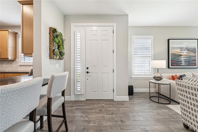 entryway with baseboards and wood finished floors