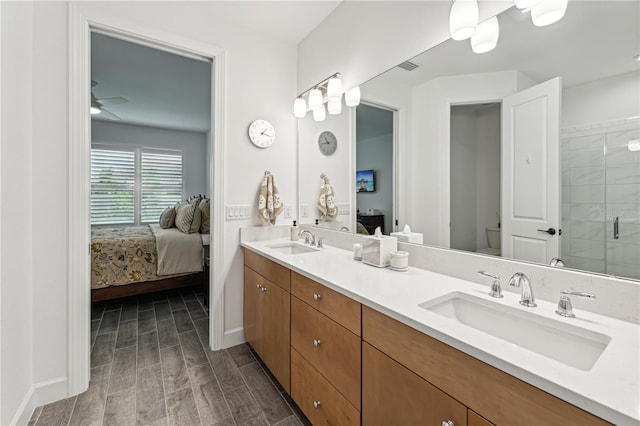 ensuite bathroom with a sink, wood finish floors, and connected bathroom