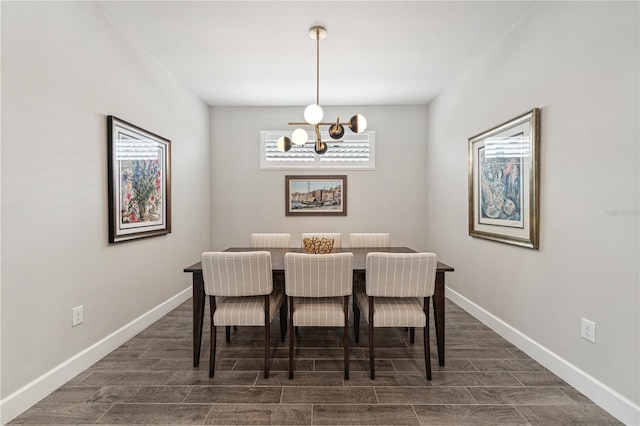 dining area featuring a chandelier, wood finish floors, and baseboards