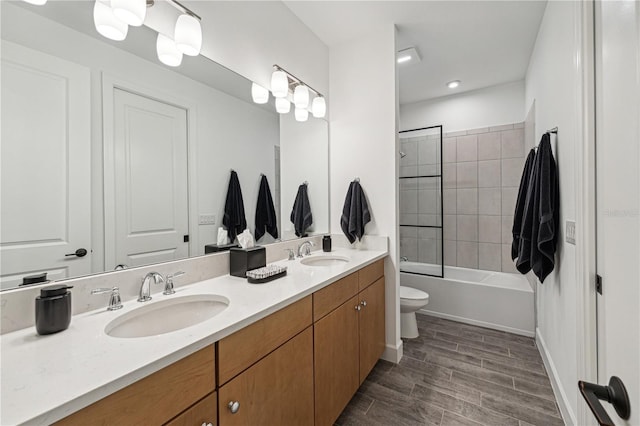 bathroom with  shower combination, a sink, toilet, and double vanity