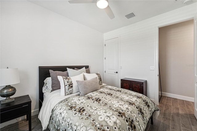 bedroom featuring a ceiling fan, baseboards, visible vents, and dark wood-type flooring