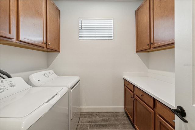 washroom with cabinet space, baseboards, and washer and clothes dryer