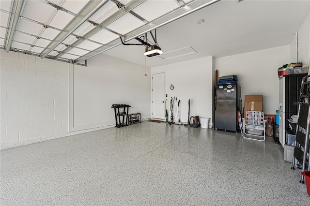 garage featuring freestanding refrigerator and a garage door opener